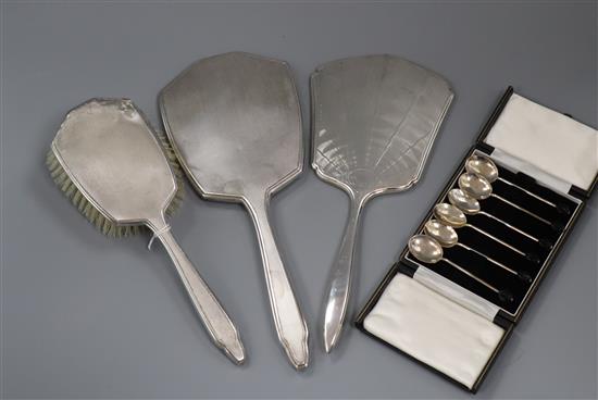 A set of six George V silver bean end coffee spoons, cased and three George V silver dressing table items.
